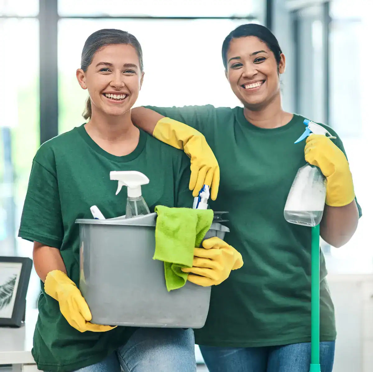 Two smiling cleaners with cleaning supplies