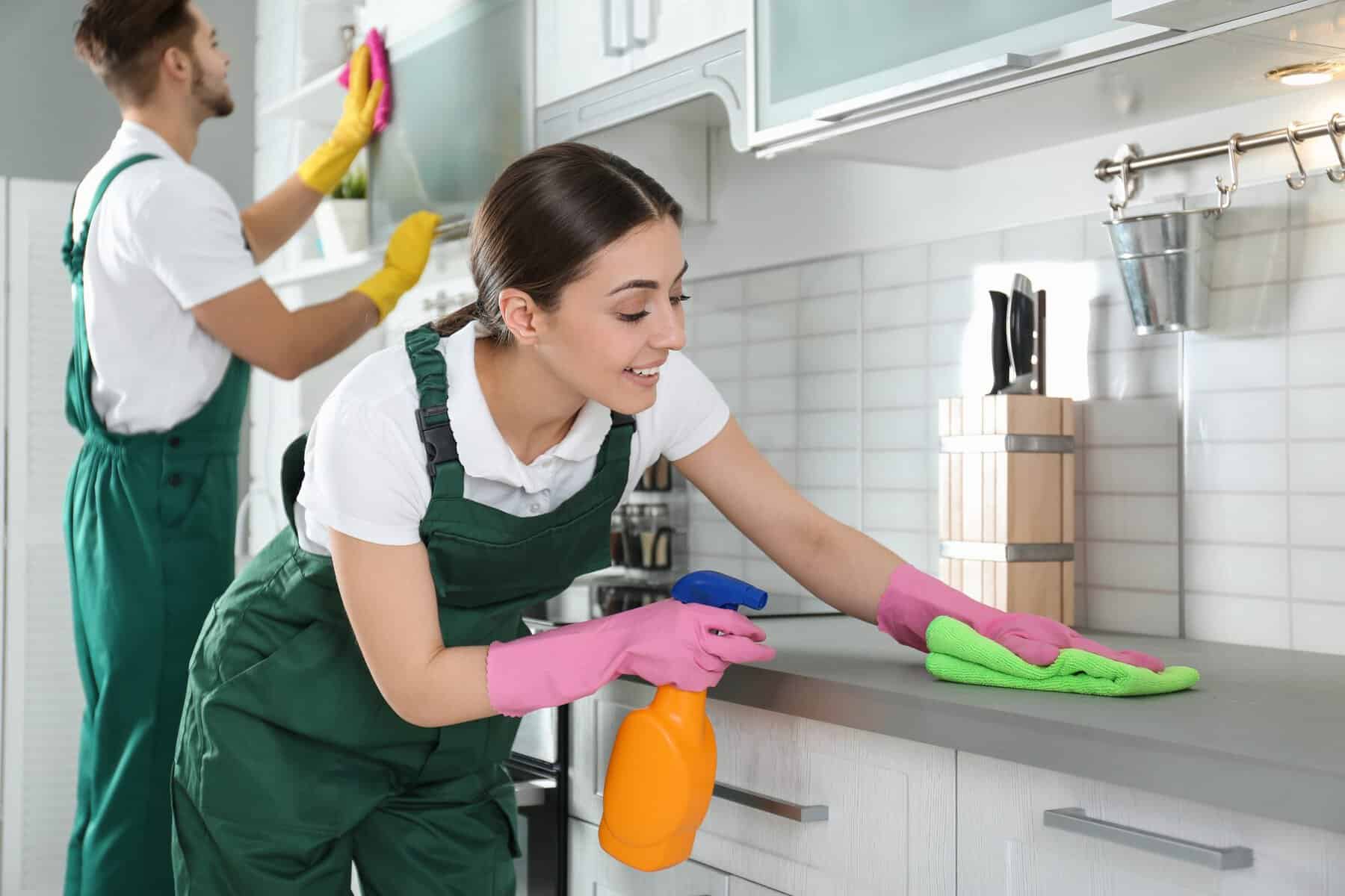 Cleaner wiping a kitchen benchtop