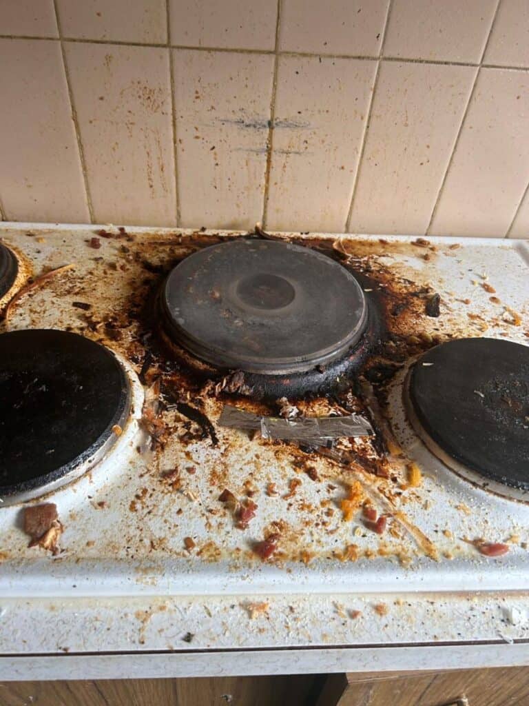 Dirty electric stovetop with burnt food before end of lease cleaning